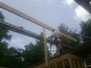 Carpenter setting a ridge beam over a new addition frame — Ice Dam Removal by Roofing Brothers in Tekoa