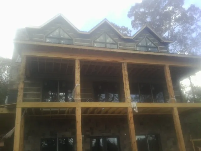 Dormers and porch framing on a large log home under construction — Roof Coating work by our crew in Tekoa