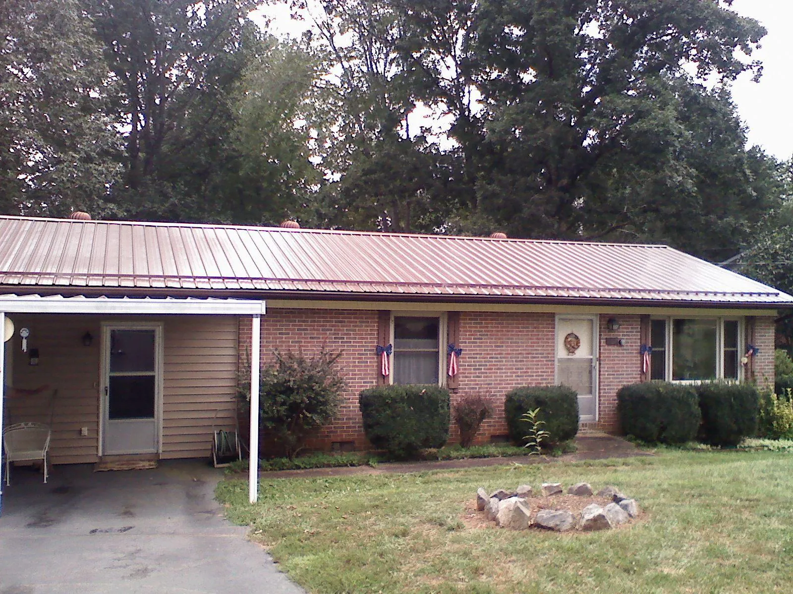 Bronze metal roof and carport on a brick ranch home — Roof Repair work by our crew in Tekoa